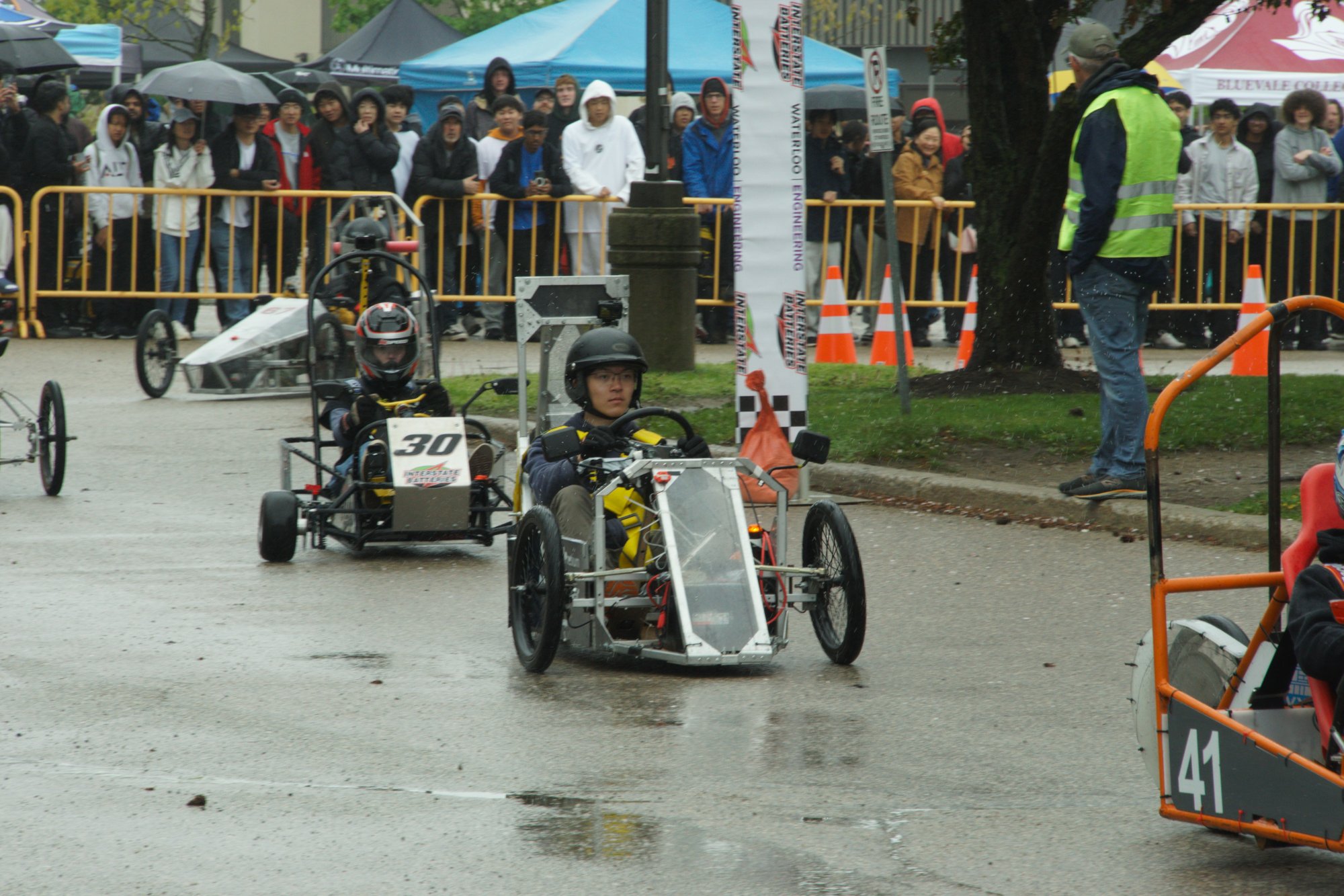 A rainy race start at the 2026 EV Challenge, crowds lining the barriers